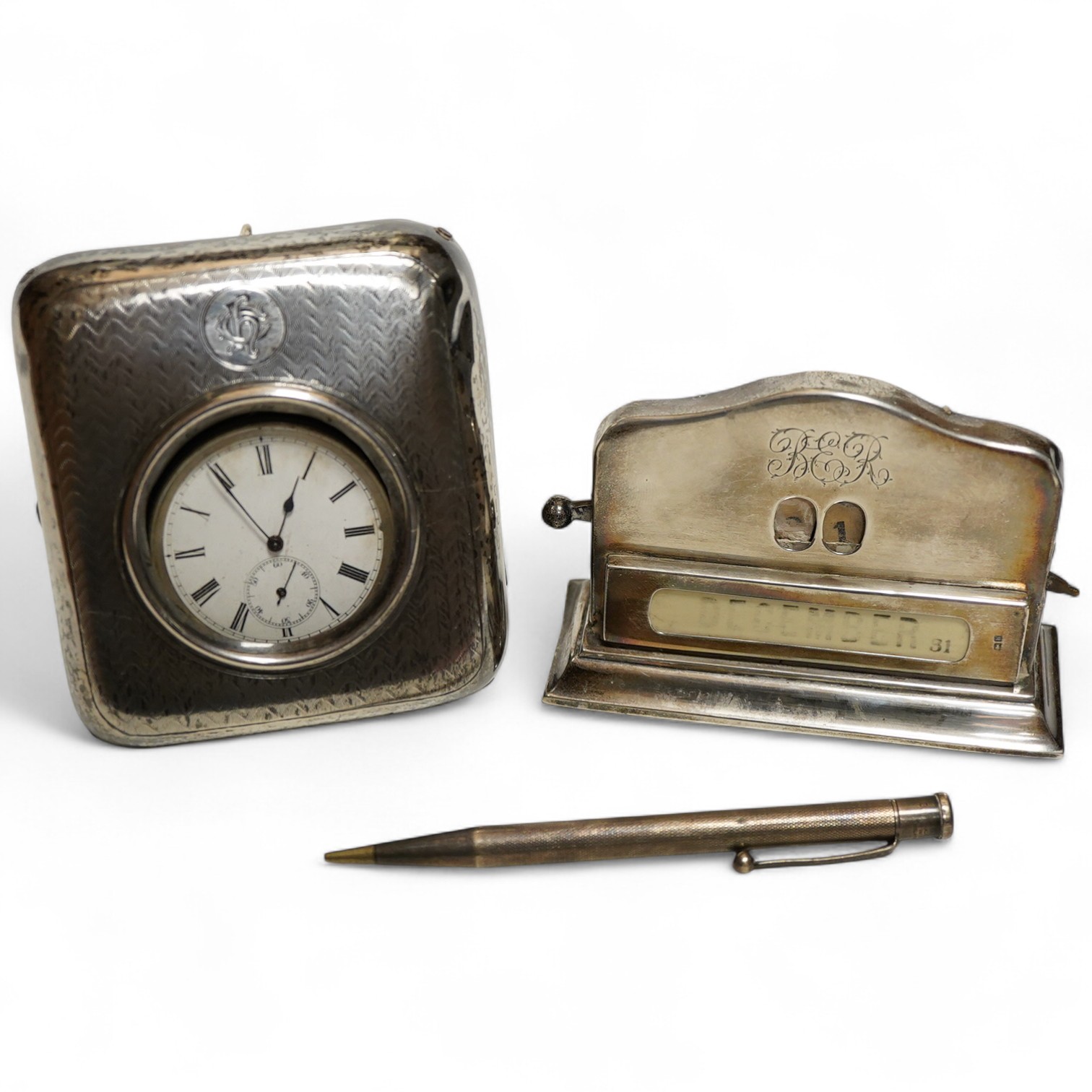 An Edwardian silver perpetual desk calendar, Birmingham, 1907, E F Braham, initalled, (mechanism a/f) together with an engine turned propelling pencil and a Swiss open faced poclet watch contained within a silver faced l